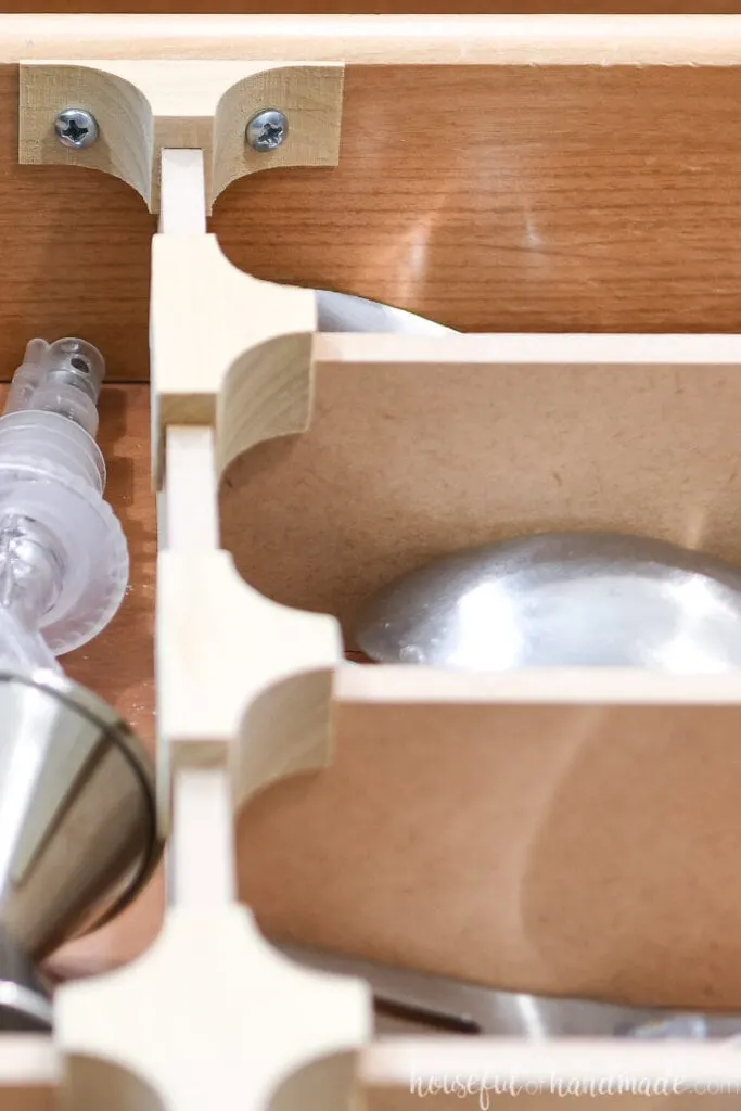 Close-up of the wood clips holding the drawer dividers together and being attached to the side of the drawer. 