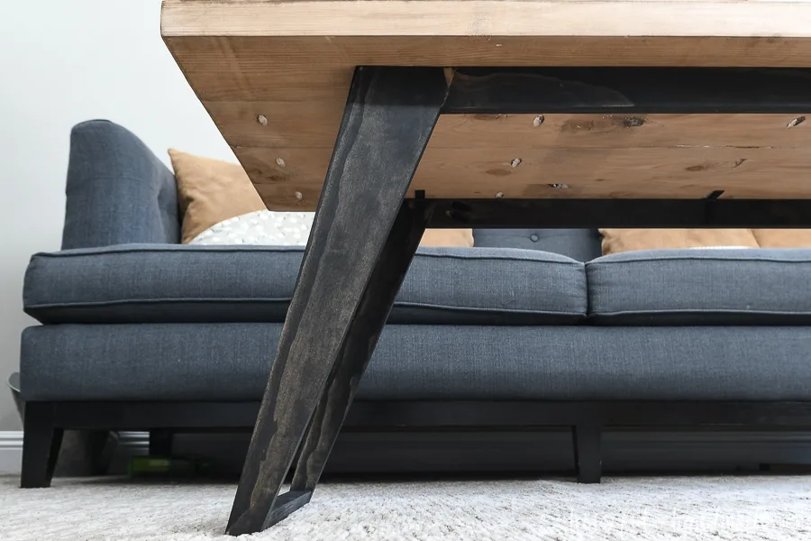 Close-up view of the angled and tapered legs attached to the underside of the coffee table top. 