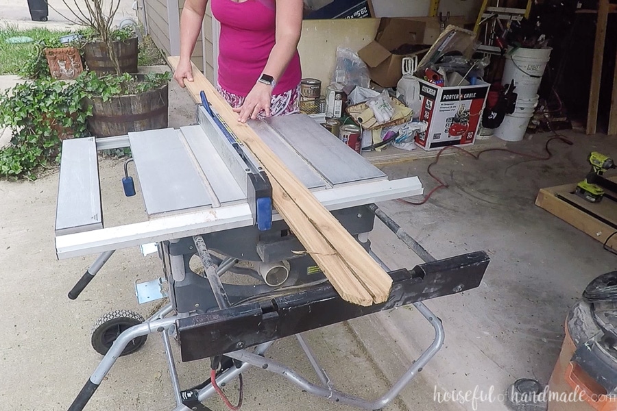 Ripping a cedar fence picket in half on a table saw.