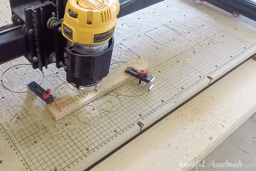 Cedar stakes clamped to the X-Carve waste board being carved for the inlay.