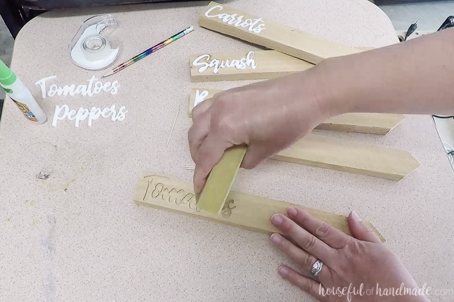 Sanding the garden markers with a sanding sponge. 