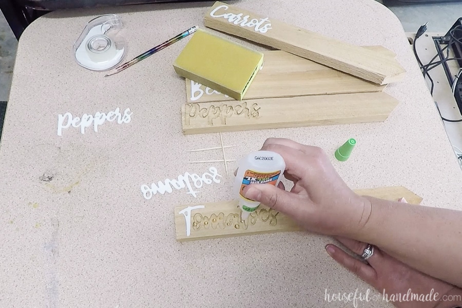 Using super glue gel to secure the inlay in the cedar garden marker. 