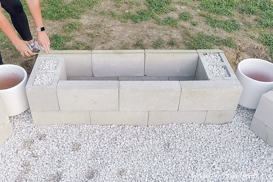 Measuring the cinder block base for the fire pit bench. 