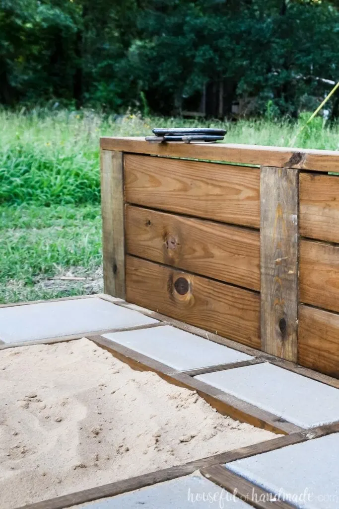 Close-up view of the sturdy backstop of the horseshoe pit built from 2x6 and 4x6 boards. 