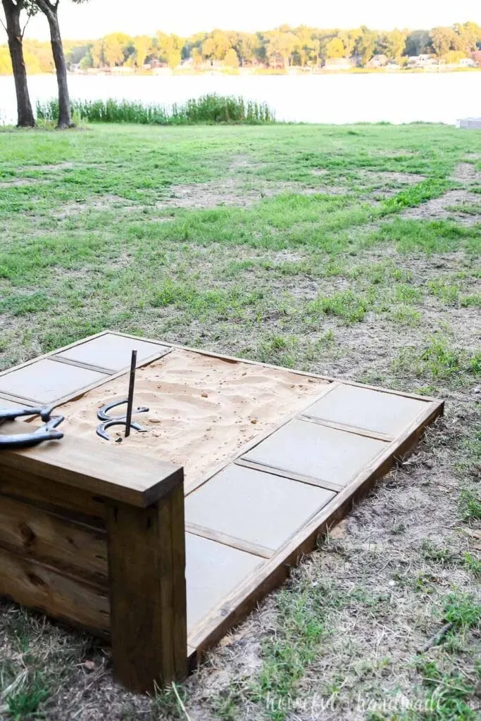 Looking over the back of the horseshoe pit toward the lake seeing the side of the throwing platform.