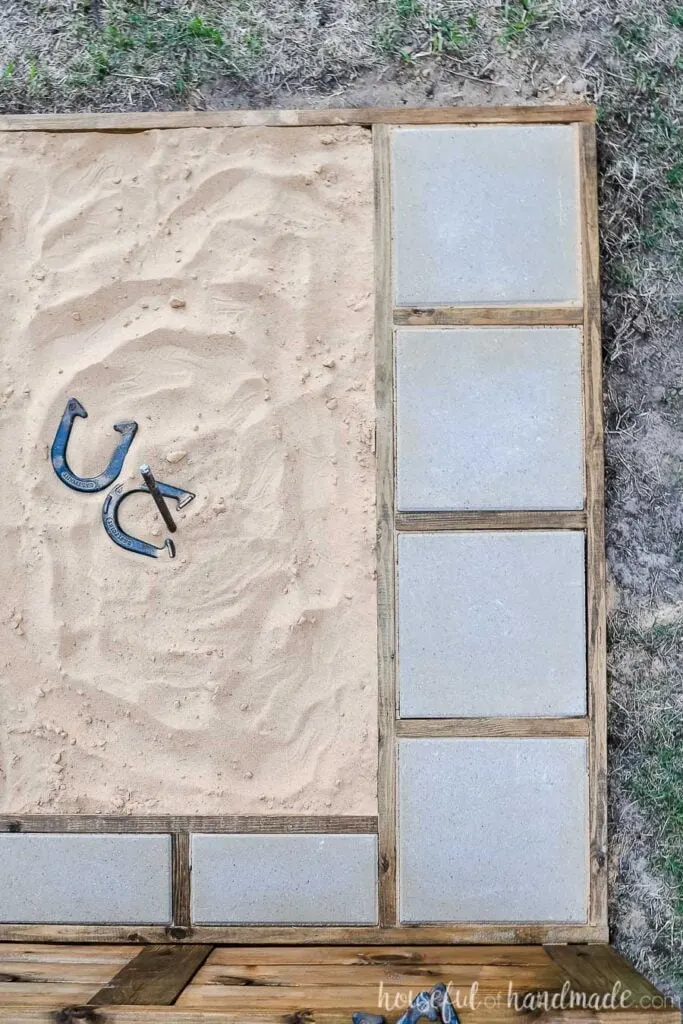 Top down view of the frame of the horseshoe pit built from 2x4s and holding concrete pavers. 