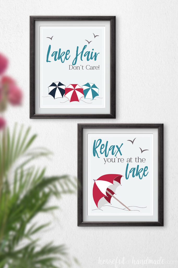 Two lake art prints in black frames hanging on the wall.