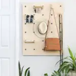 Entryway organizer made from plywood hanging on the wall next to a door.