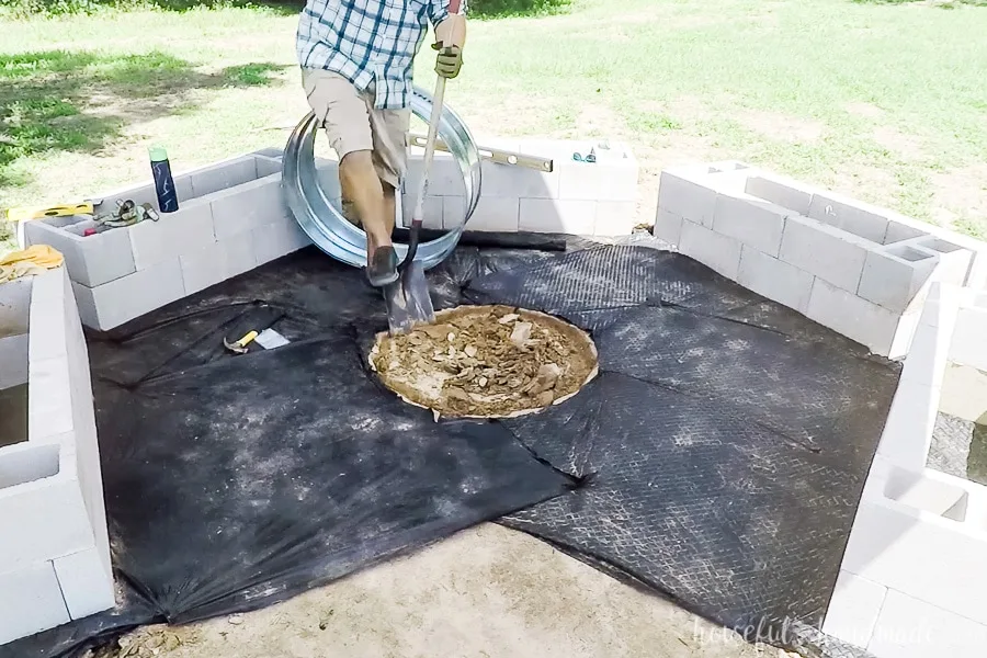 Digging out a hole in the center of the fire pit area to put the fire ring into. 