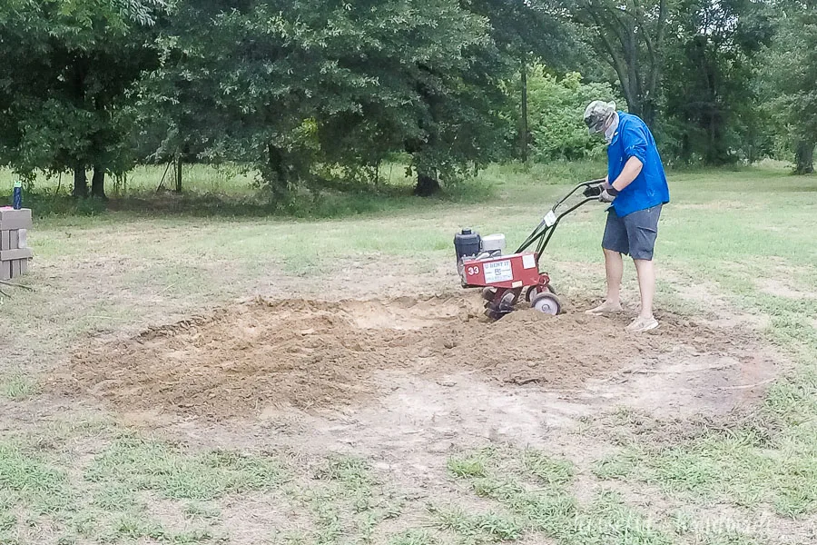 Using a front tine tiller to break up the ground for the DIY fire pit. 