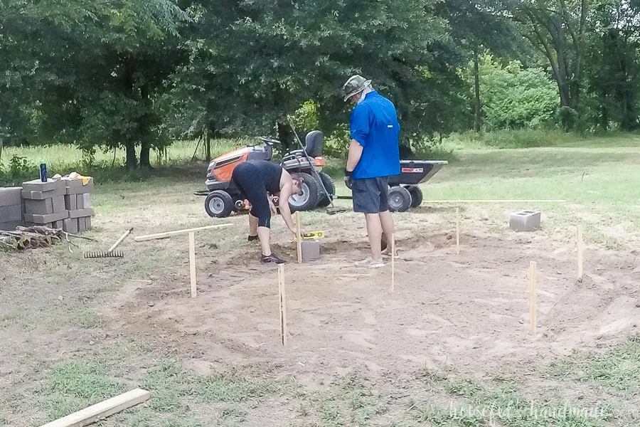 Leveling the first cinder block for the fire pit seating area. 