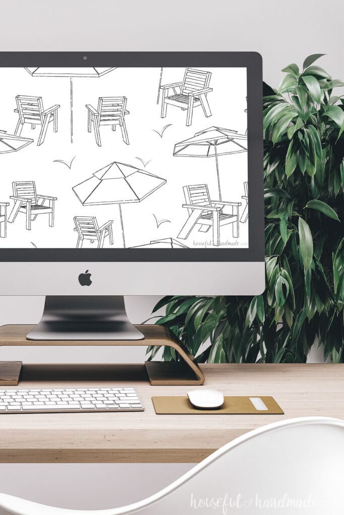 Desk with computer on it and modern toile inspired digital wallpaper on the computer background.