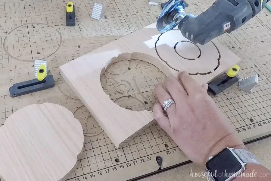 Removing the carved pieces from the wood with a saw.