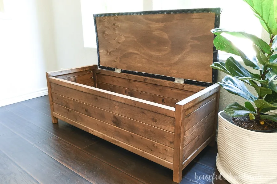 Brown wood storage bench with top opened showing the large storage compartment.