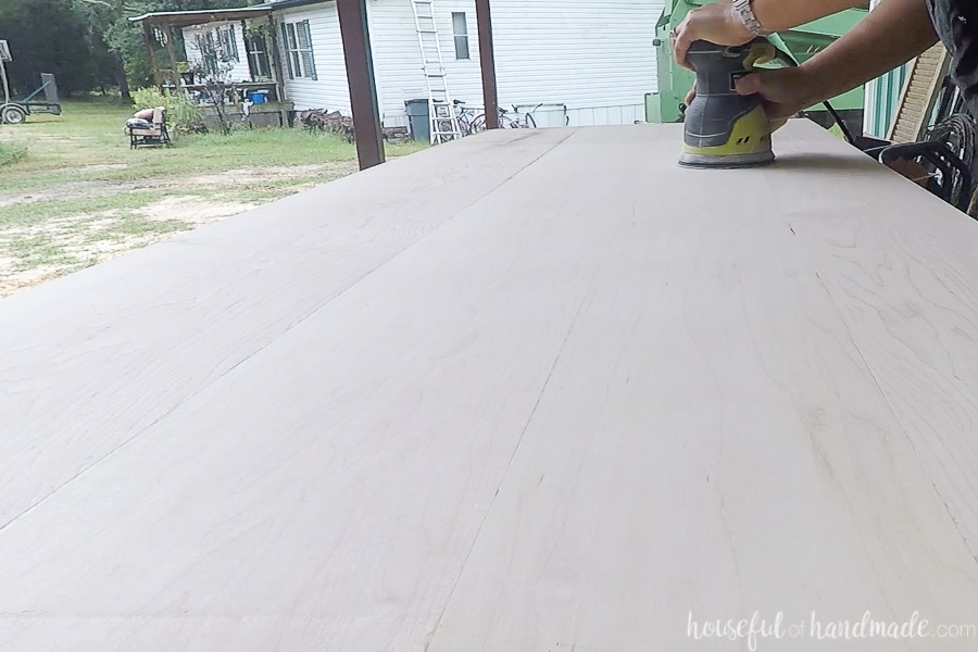Sanding the surface of the countertops with an orbital sander. 