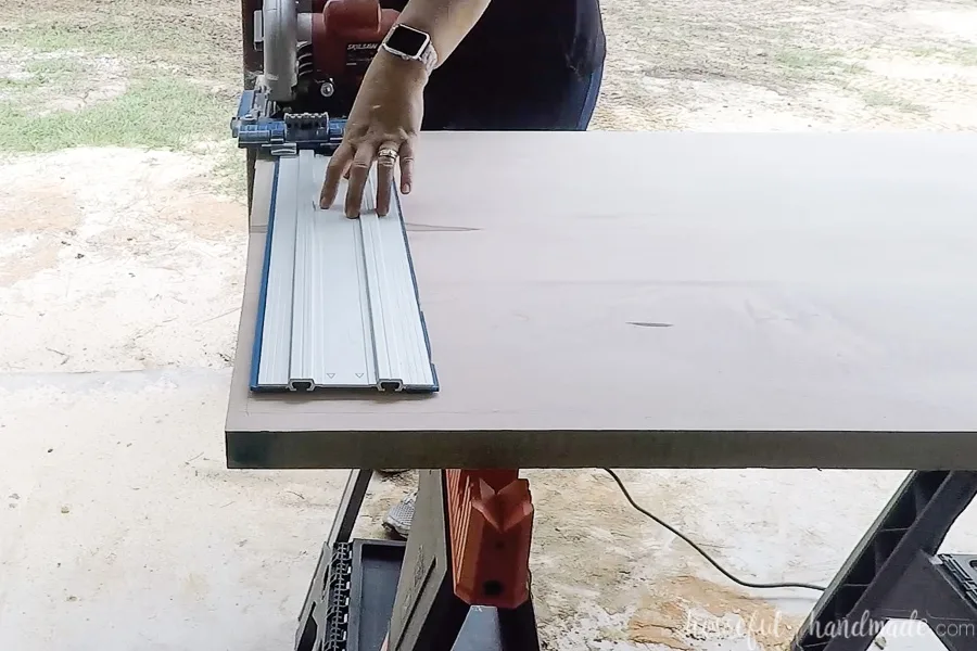 Cutting the edge of the countertop to template with a circular saw and guide track.