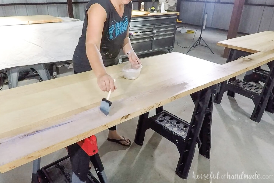 Applying the first coat of waterproof finish to the countertops with a foam brush.