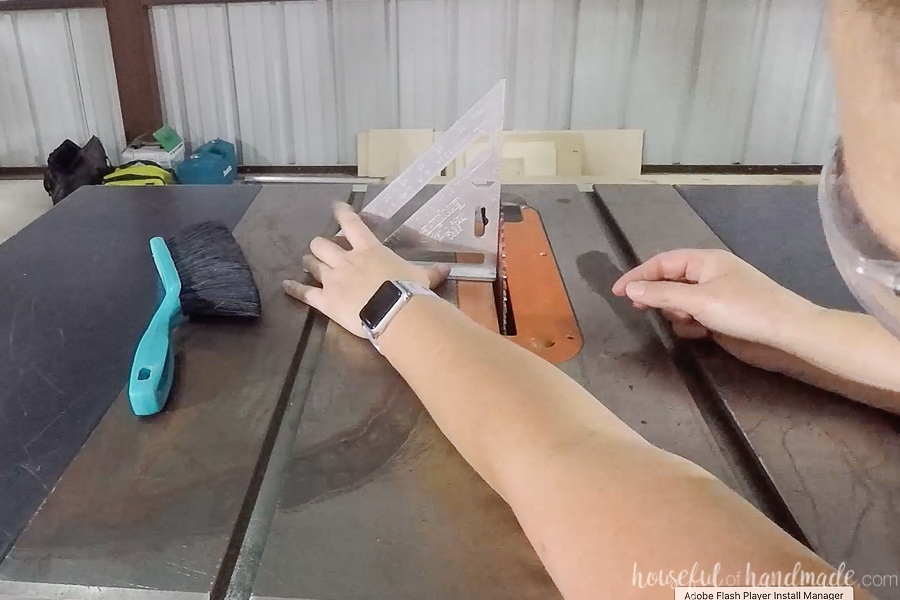 Using a square to square up the table saw blade. 
