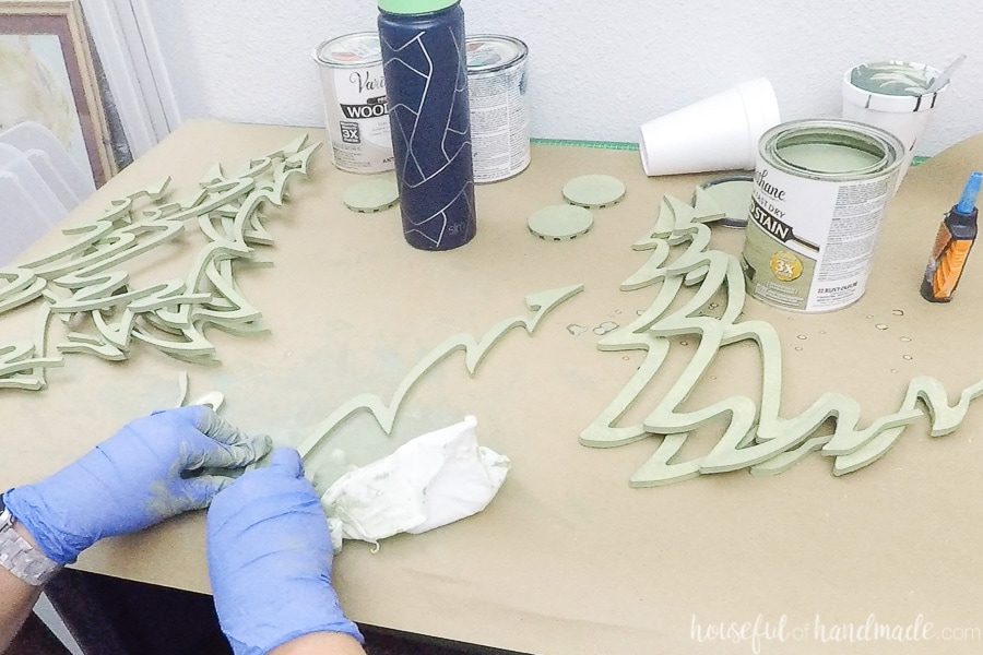 Staining the pieces of the classic shaped wood Christmas tree with Rustic Sage wood stain. 