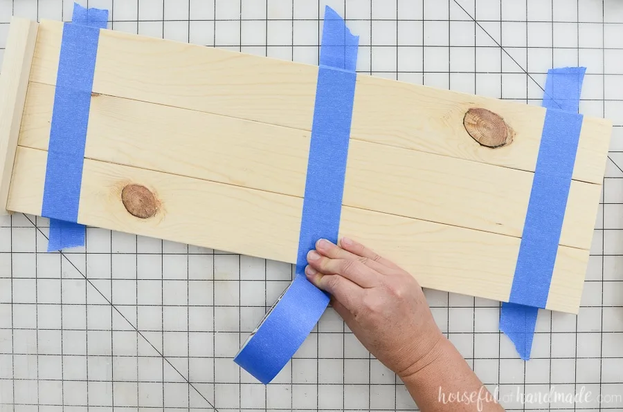 Holding the three boards together with blue painters tape while the glue dries. 