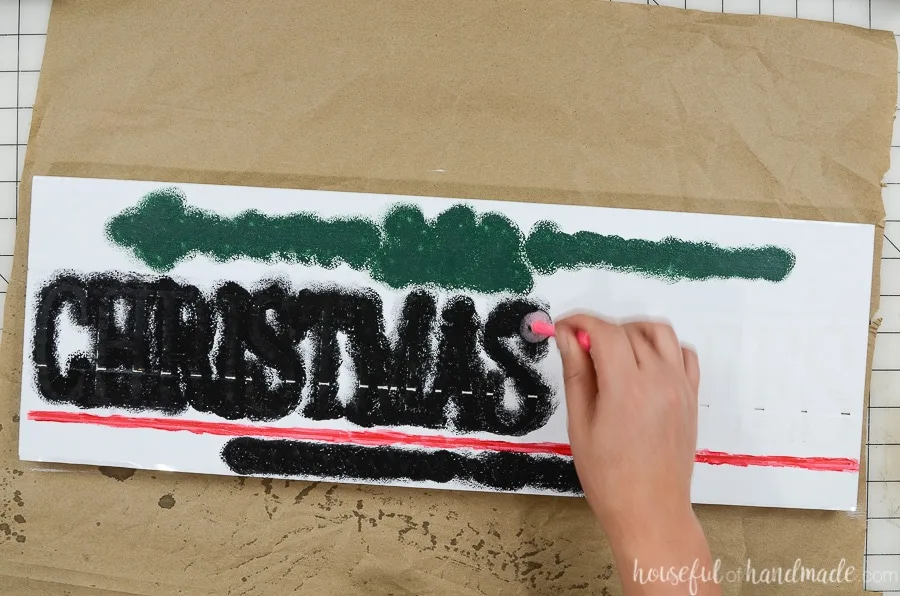 Stippling black, red and green craft paint over the Christmas tree vinyl stencil. 