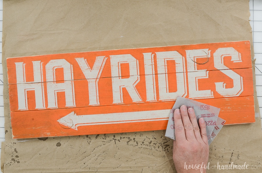 Sanding the hayrides side of the double sided sign by hand to give it a warn look.