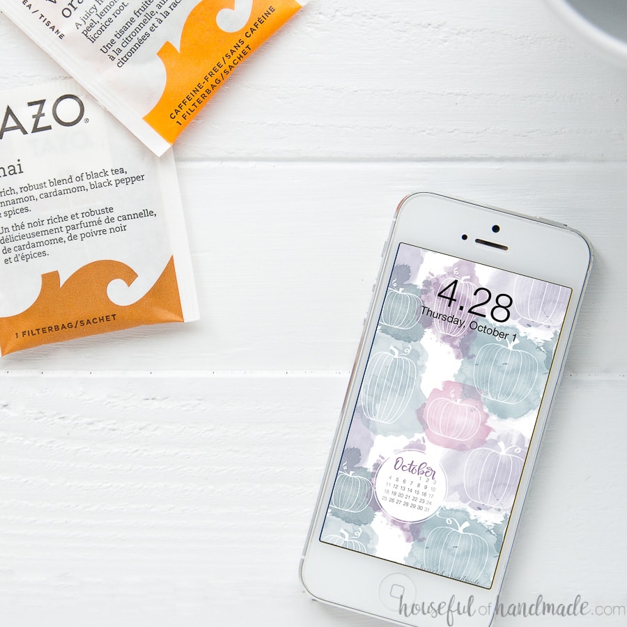 Smartphone with the October digital wallpaper with the month's calendar on the screen.