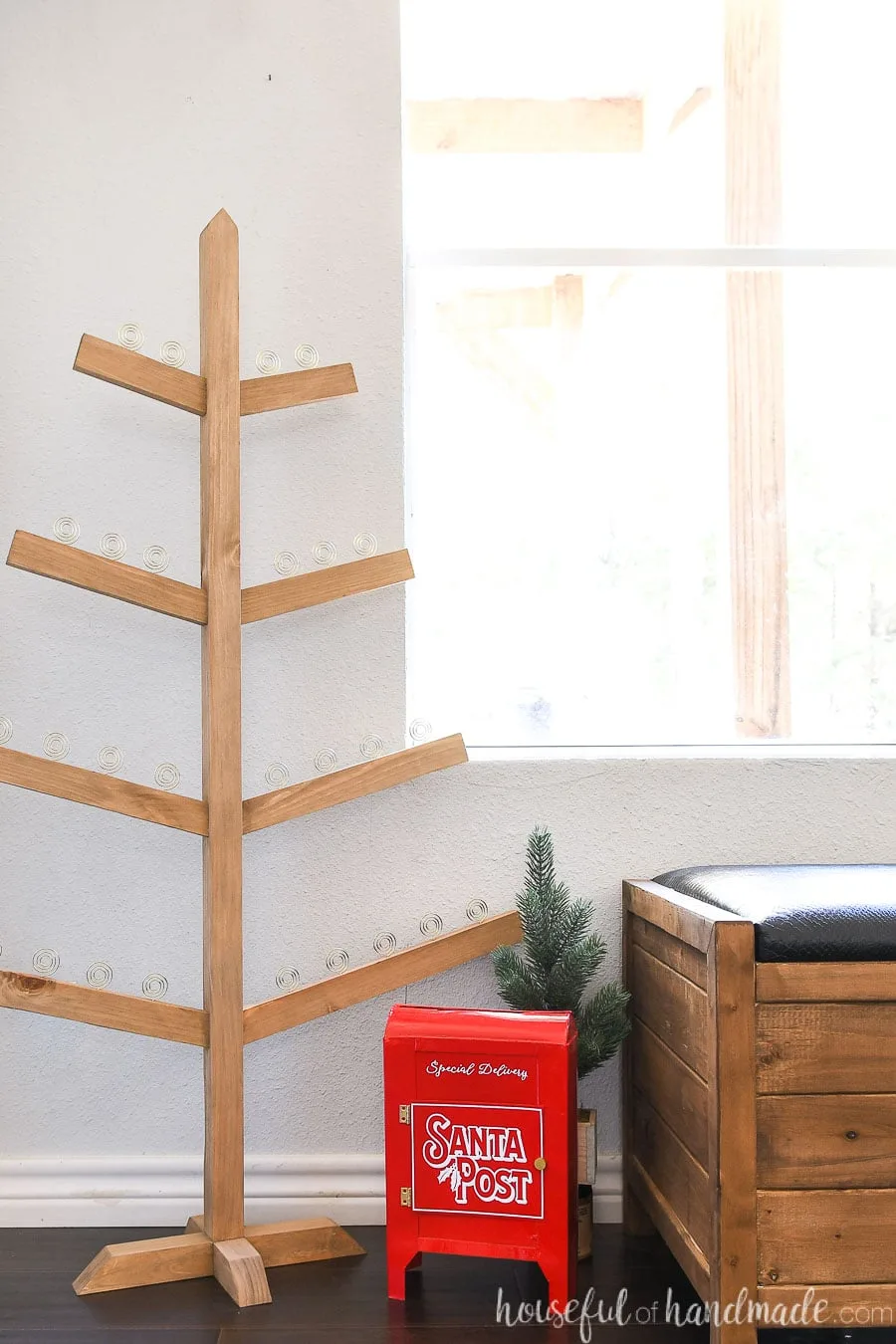 Christmas tree shaped Christmas card holder without any Christmas cards in the loop holders in an entryway.