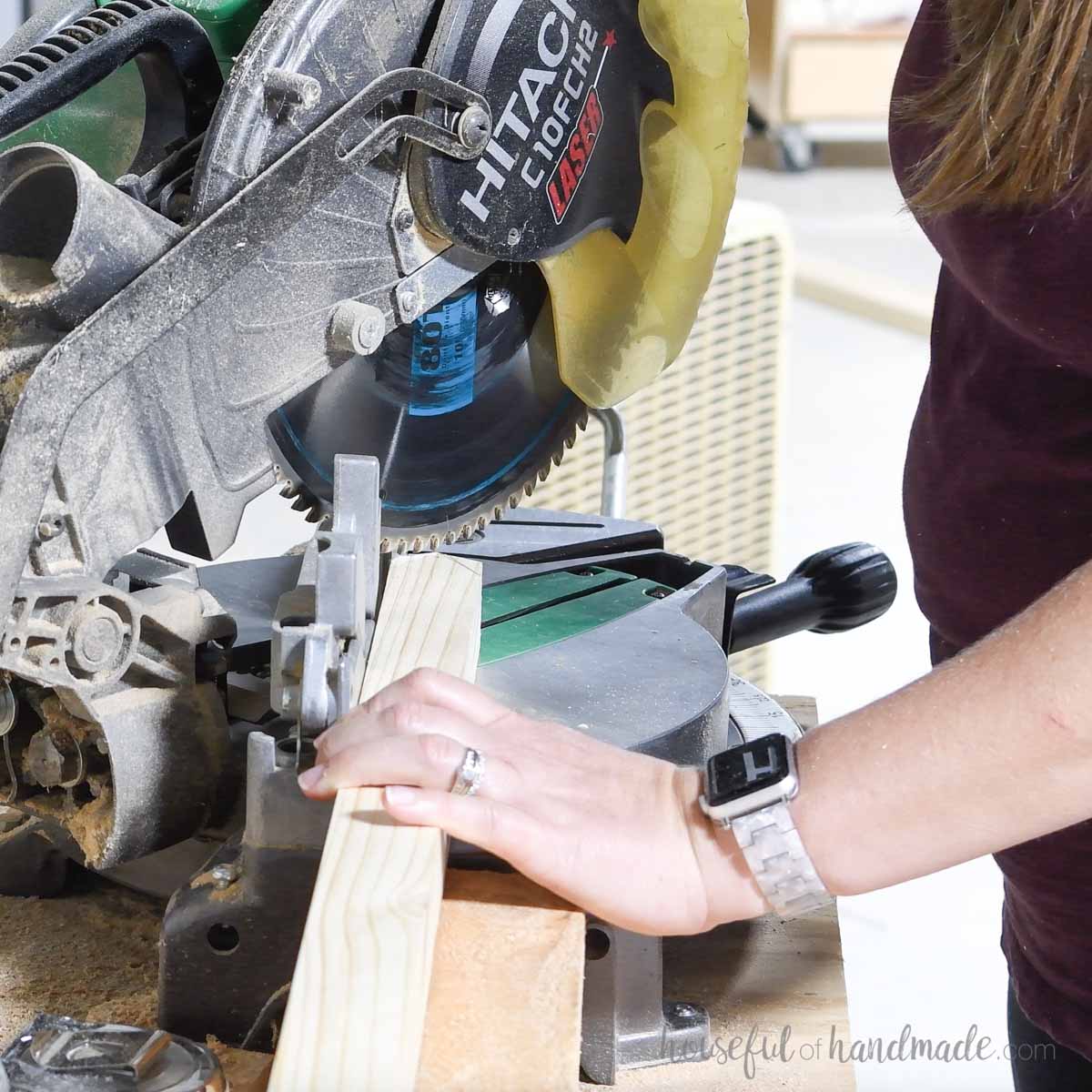 Cutting a point on the top of a 2x2 board with a miter saw. 