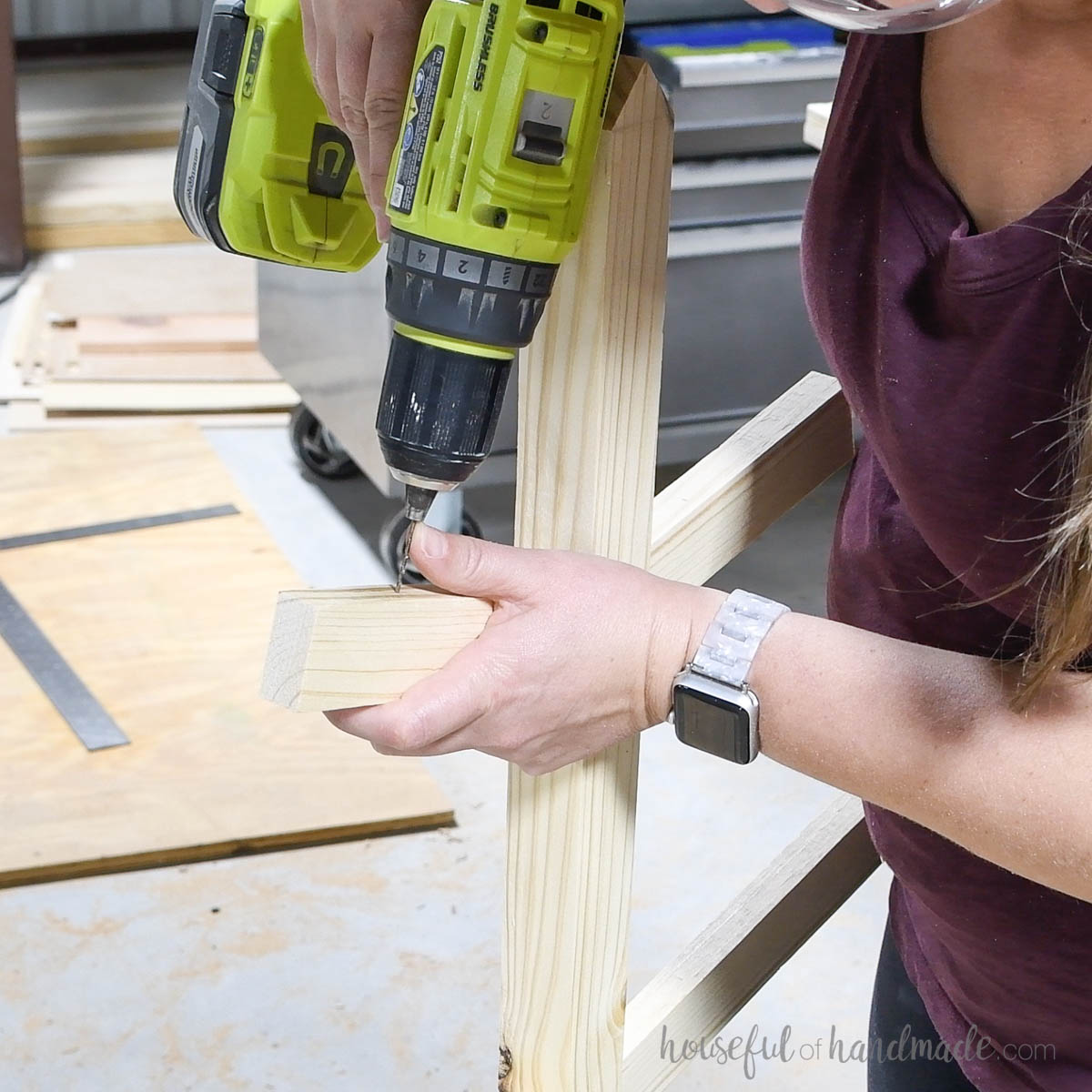 Drilling a hole in the top of the tree limb board. 