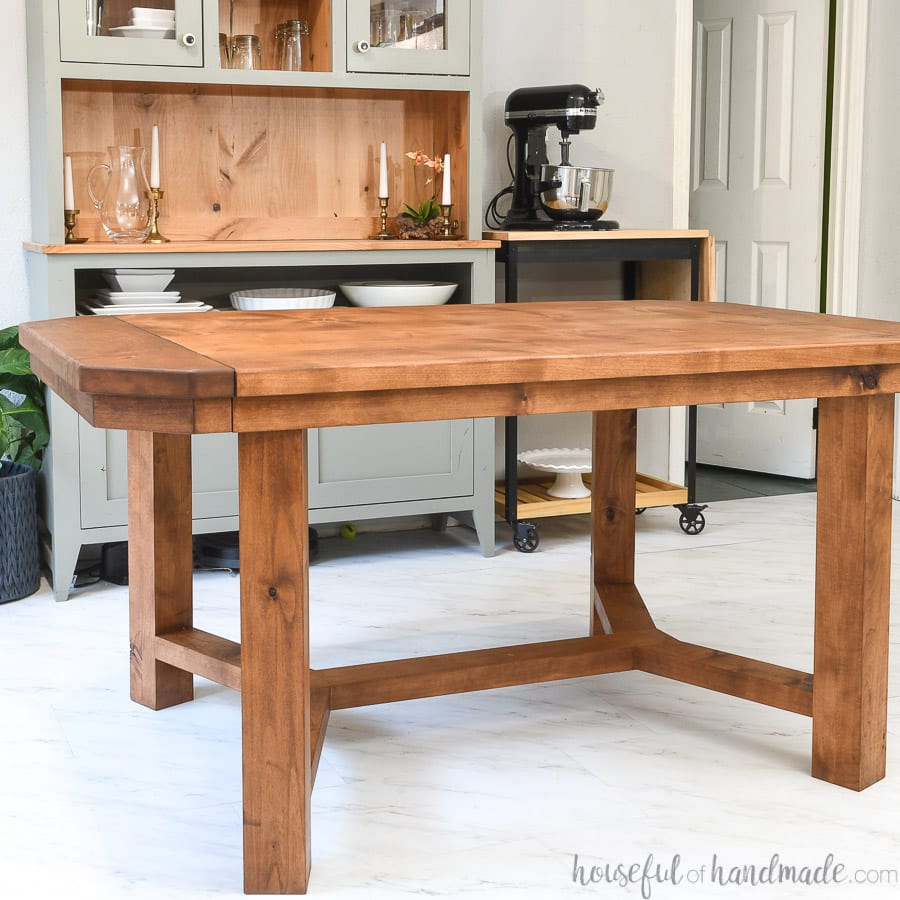 DIY trestle dining table with 2 leaves in the dining room in front of a hutch.