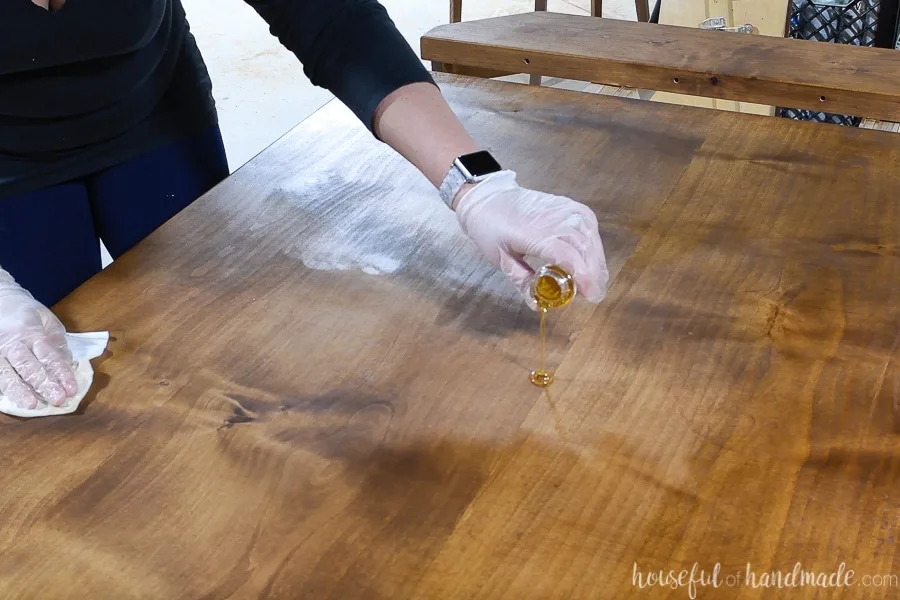 Pouring a puddle of TrueTone buff in finish on the stained table top.