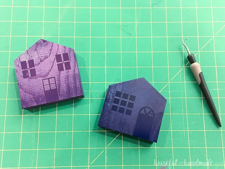 Two of the houses painted with navy and purple paint with the vinyl still on it.