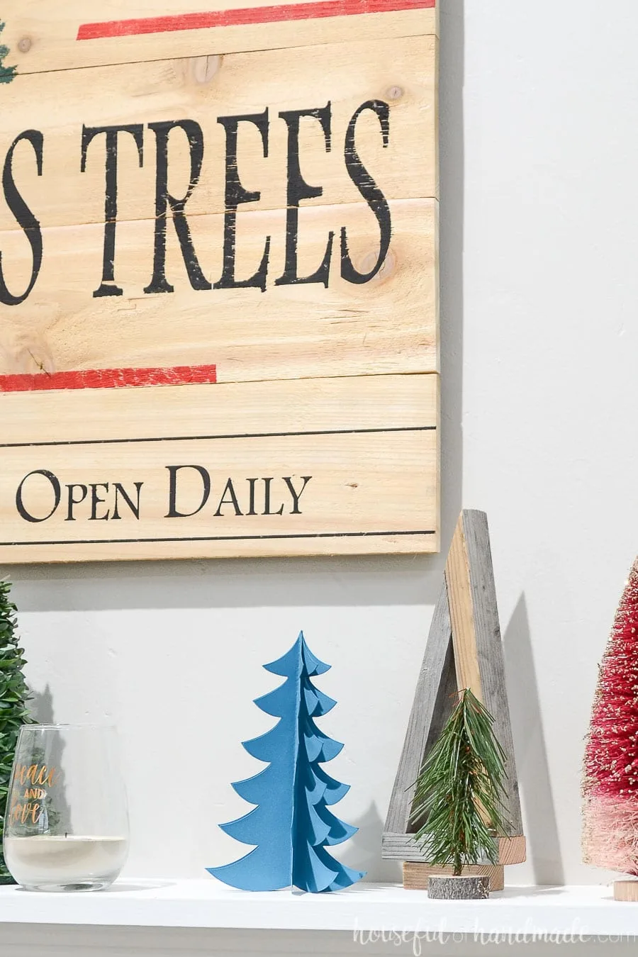 Close up of some of the Christmas trees on the holiday mantle.