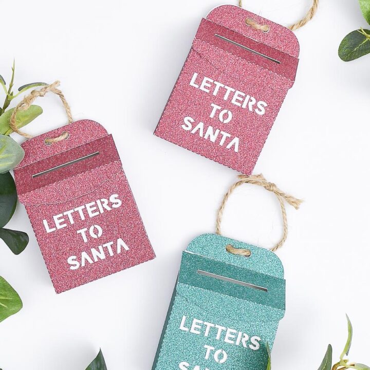 Three glittery Letters to Santa mailbox ornaments on a white background.