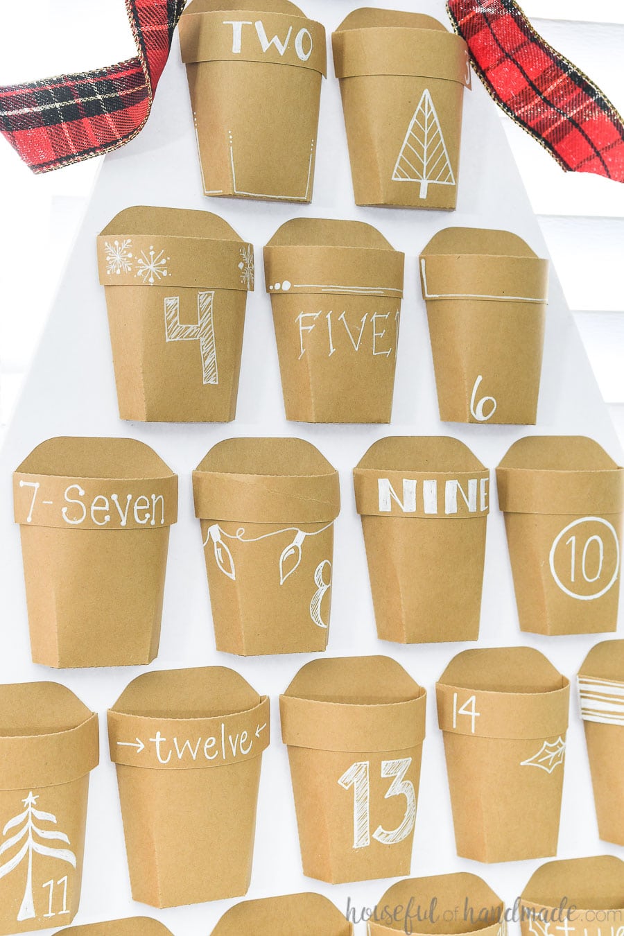 Close up of the decorated brown Kraft paper pockets on the front of the advent calendar.