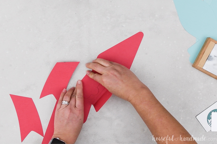 Folding the flaps on the paper bows cut out of red cardstock.