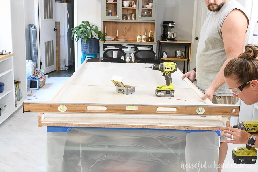 Attaching the form to the second side of the countertop form with a 4' level across the top of both forms so they stay level.