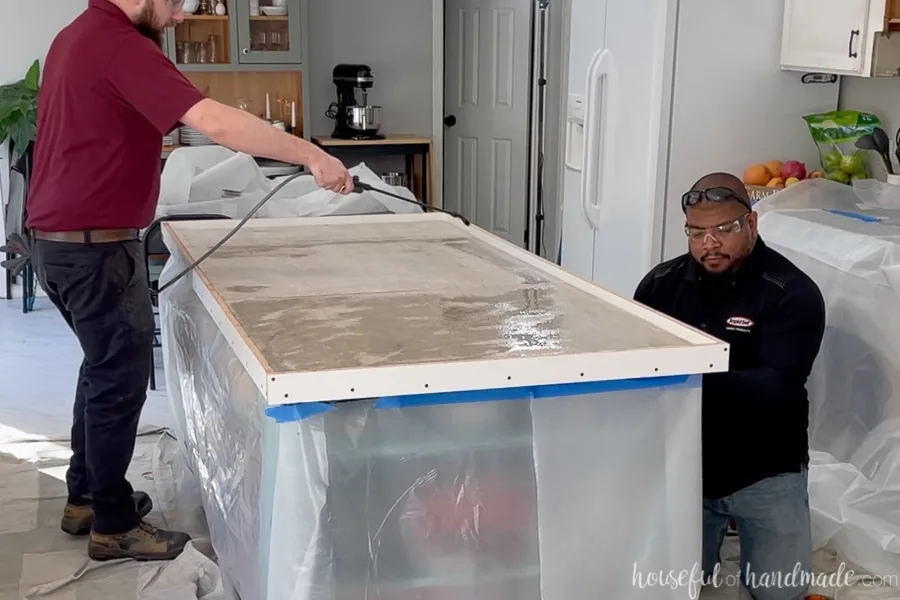 Wetting the cement board inside the concrete form with a pump sprayer filled with water. 