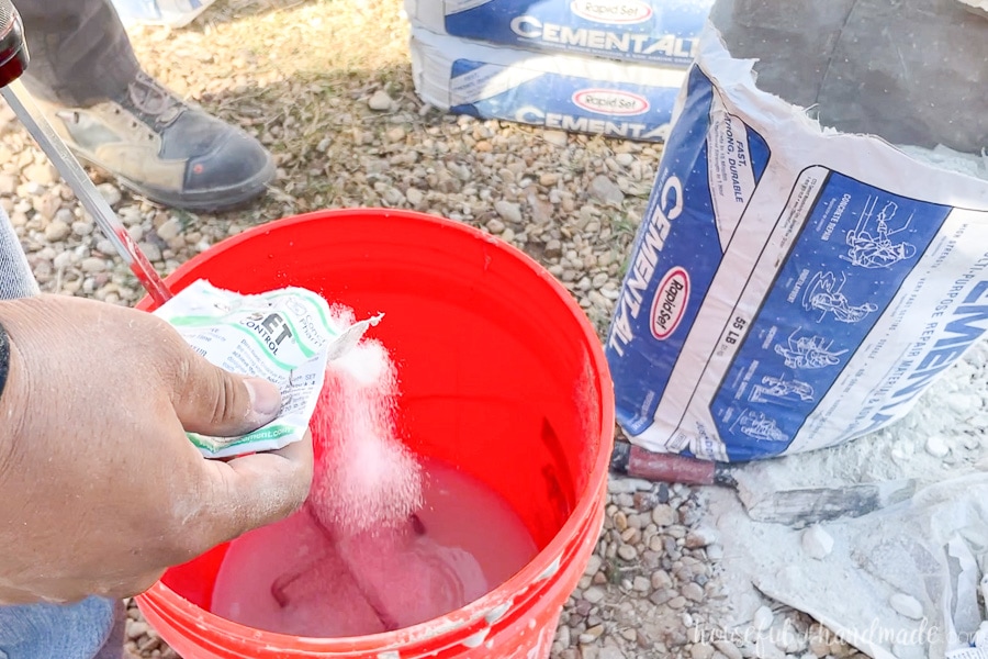Pouring Set Control into a 5 gallon bucket filled with water next to an open bag of Cement All.