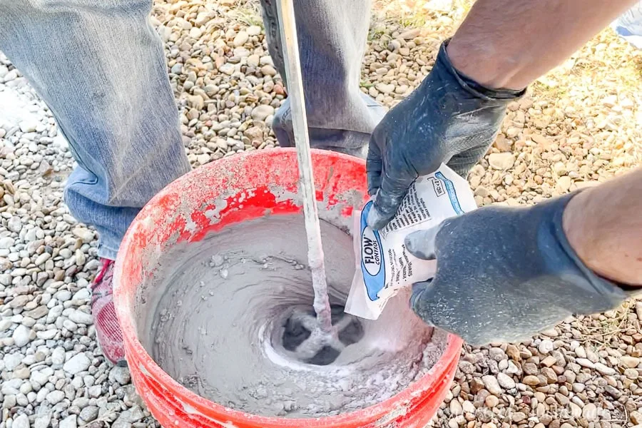 Pouring Flow control into the mostly mixed concrete in the 5 gallon bucket. 