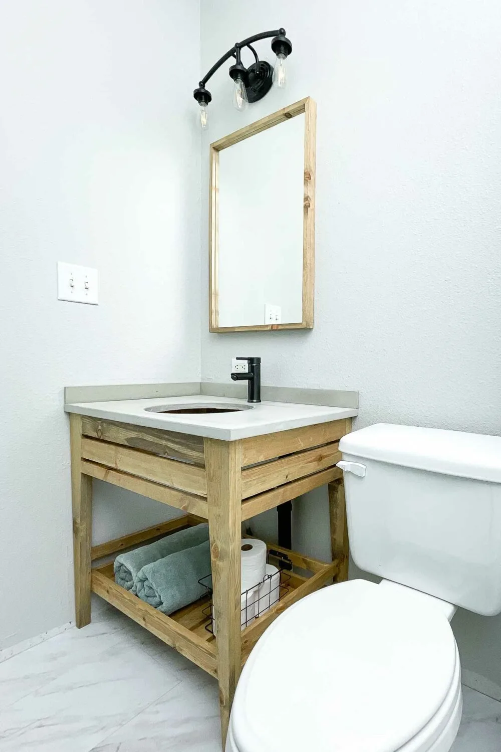 DIY open bathroom vanity in the budget bathroom remodel with a concrete countertop.