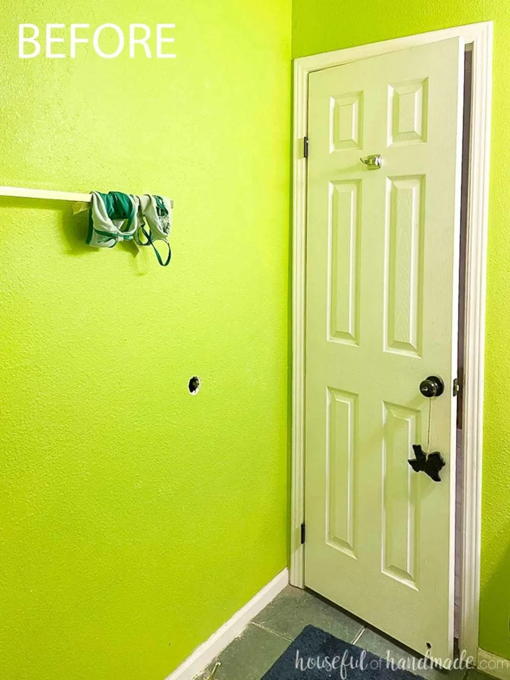 Before photo of the bathroom with electric green walls looking at the wall behind the white 6 panel door. 