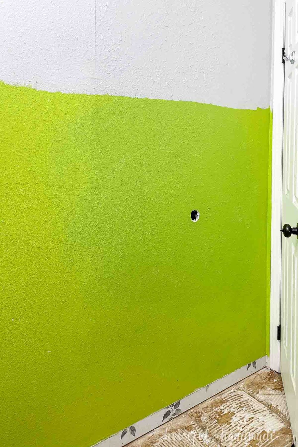 Wall behind the door with the old green paint still on the lower 2/3rds of the wall and the new gray paint on the upper part. 