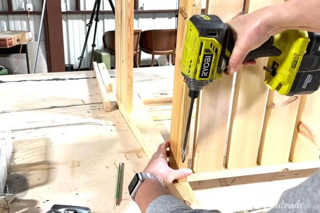 Attaching the shelf to the legs of the open bathroom vanity using the pocket hole on the bottom corners. 