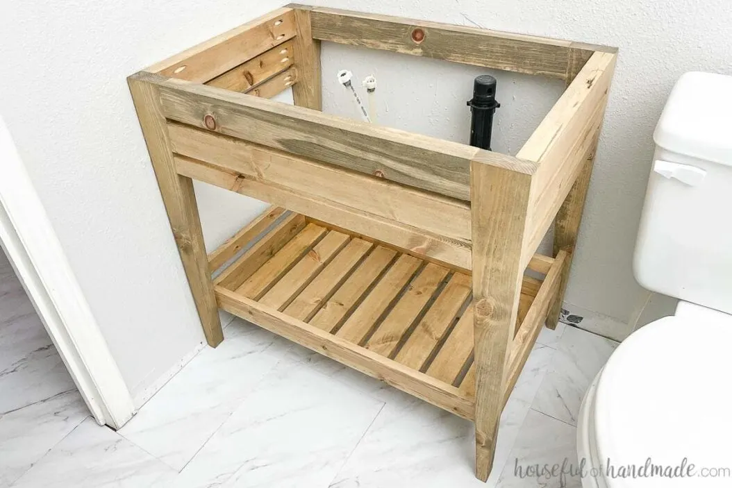 Picture of the finished DIY bathroom vanity with an open shelf and tapered legs. 