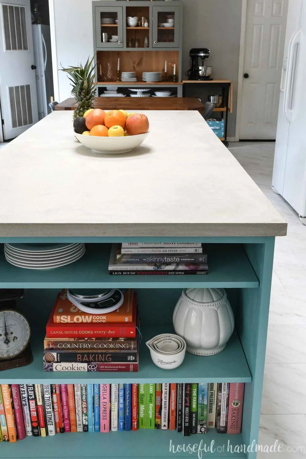 Looking down the kitchen island with a bookshelf on the end and a DIY concrete countertop made from RapidSet concrete on the top. 
