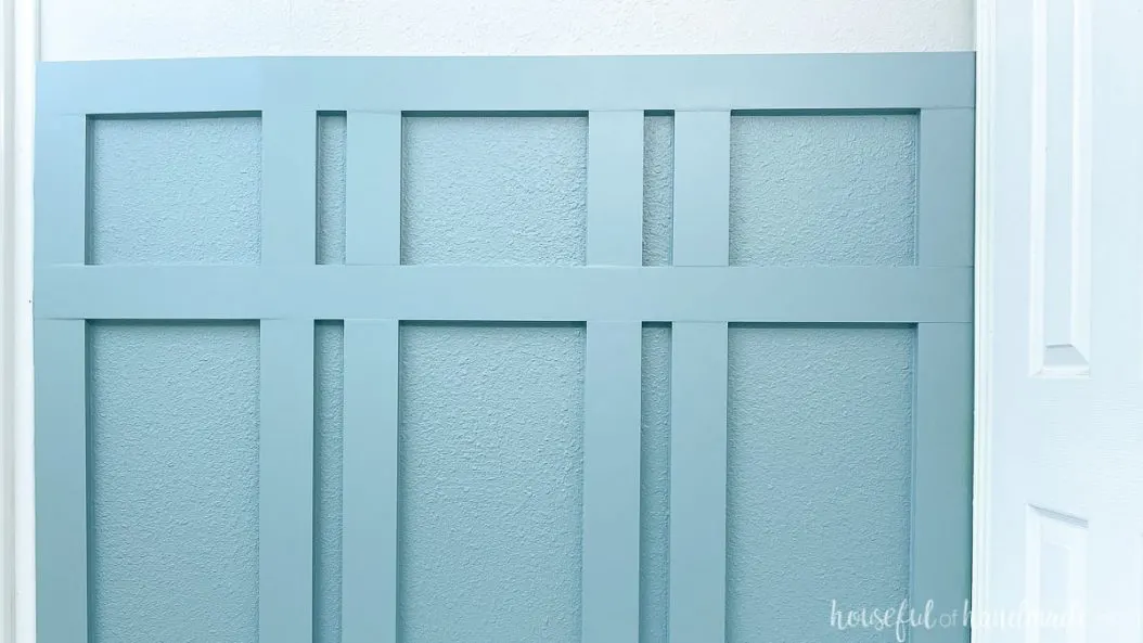 The top section of the DIY board and batten in the bathroom with a second horizontal board for attaching towel hooks. 