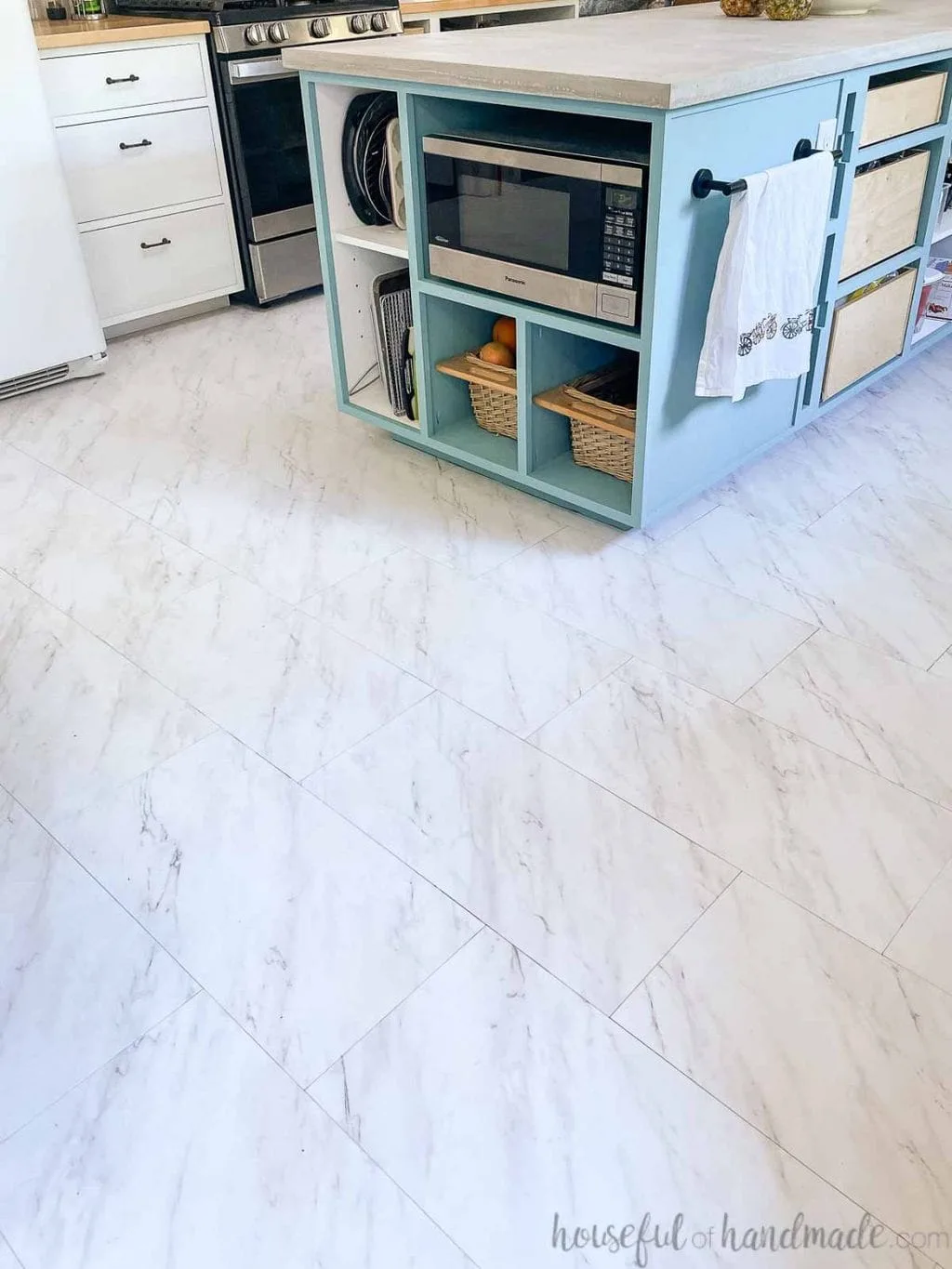 Marble look peel and stick vinyl tiles installed on the floor in a kitchen and dining room. 