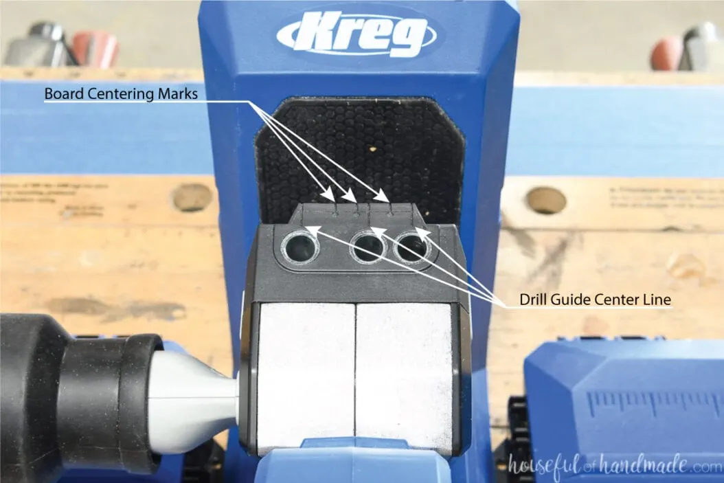 The top of the Kreg Jig 720 with arrows pointing out the center of the drill guides and the board centering marks.